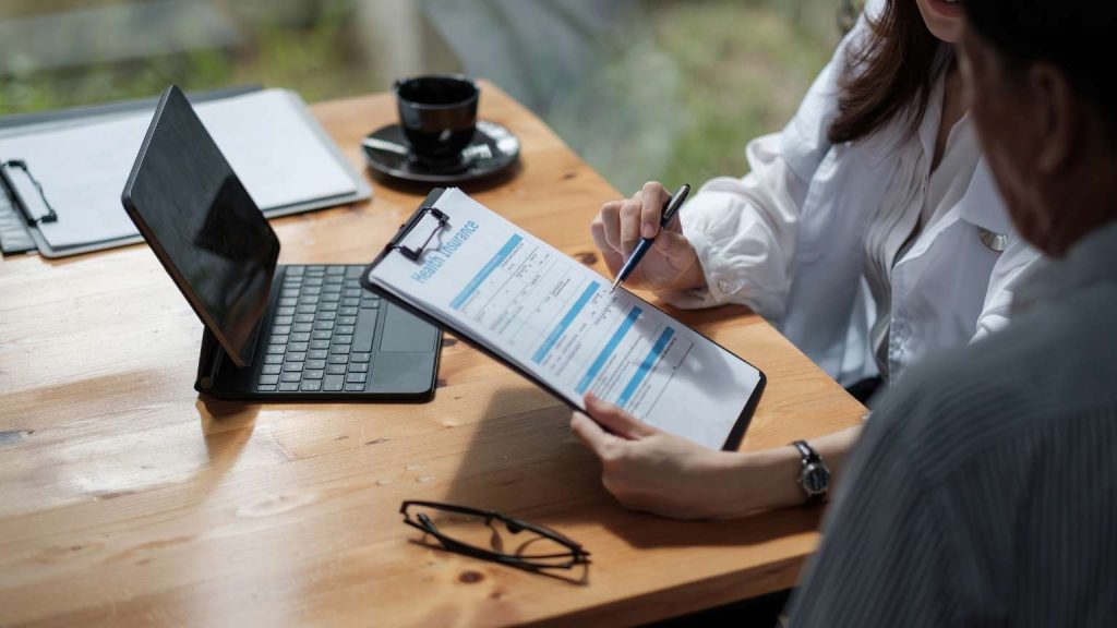 Persona comparando compañías de seguros en ordenador para elegir la mejor opción según su perfil personal o profesional