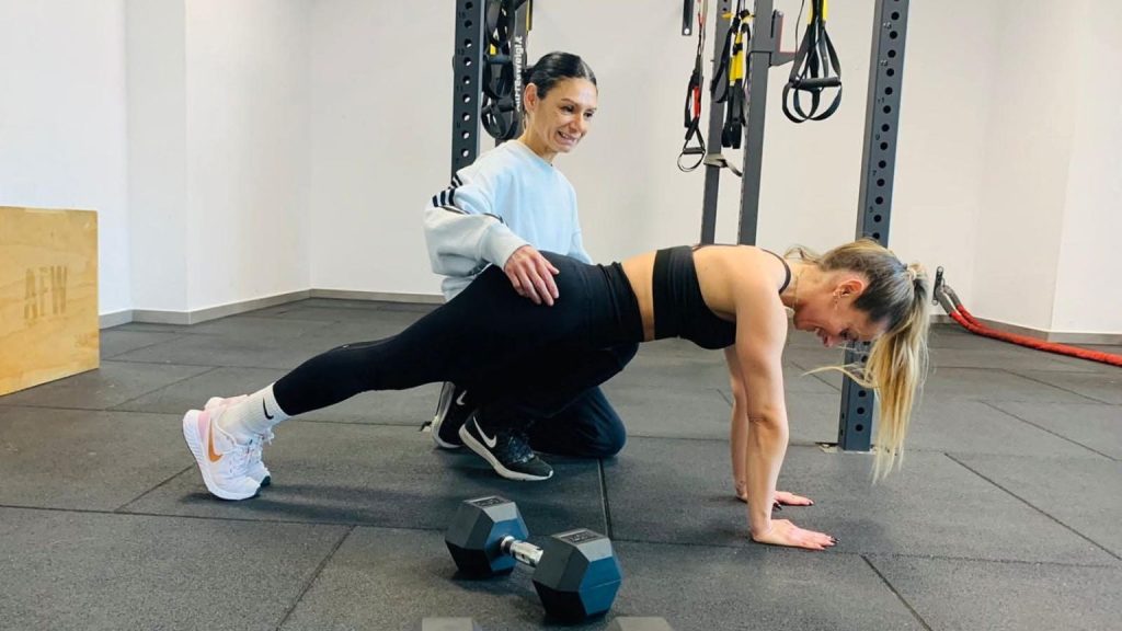 Mujer entrenando con entrenadora personal experta en entrenamiento para mujeres.