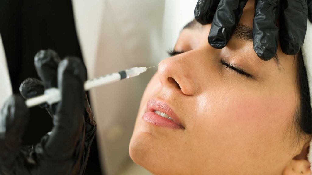 Mujer recibiendo un tratamiento de medicina estética en Marbella con inyección facial, representando procedimientos mínimamente invasivos que mejoran la salud, la confianza y el bienestar en una clínica estética profesional.