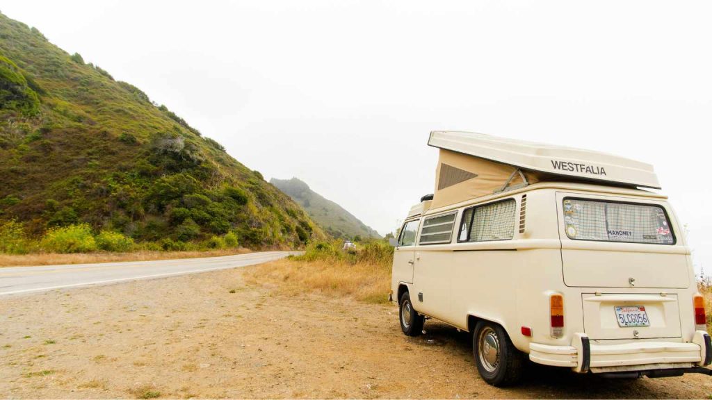 Furgoneta camper estacionada en ruta costera, representando la libertad de viajar en caravana por Valencia con la tranquilidad de contar con un parking seguro.