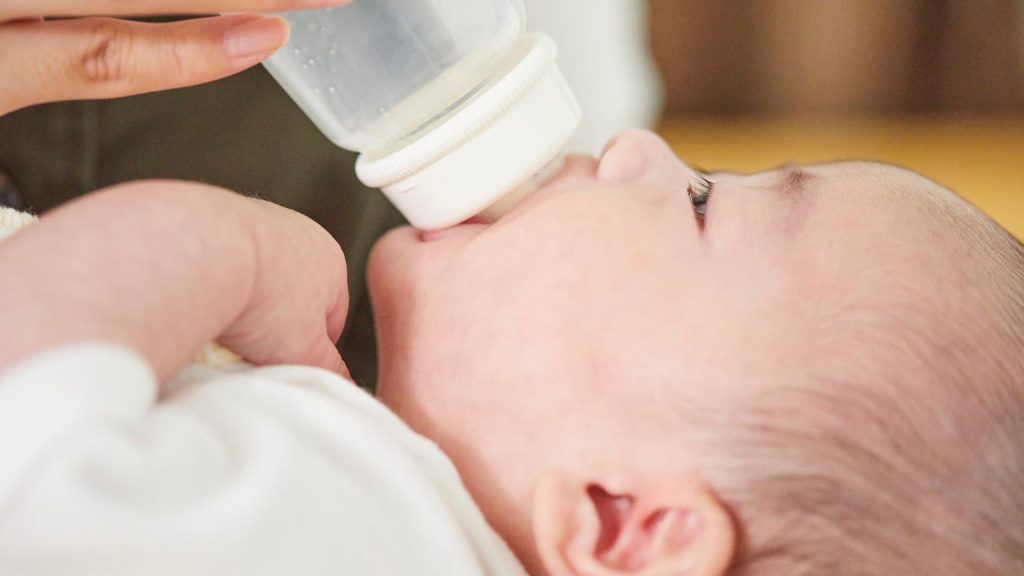 Bebé tomando leche con biberón como parte de su alimentación infantil antes de dormir