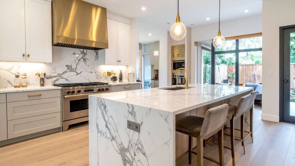 Cocina moderna diseñada con arquitectura de interiores, donde la estructura, los materiales nobles y la iluminación cálida crean un espacio funcional y sofisticado.