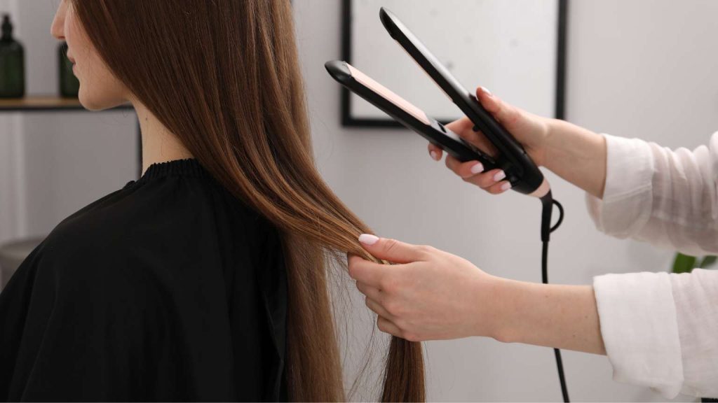 Cliente en proceso de alisado japonés en peluquería de Barcelona, tratamiento profesional para cabello liso y sin frizz.