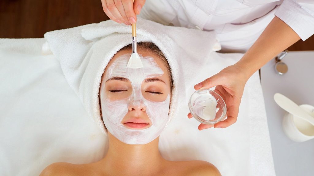 Mujer disfrutando de un masaje facial profesional para mejorar su cuidado facial.