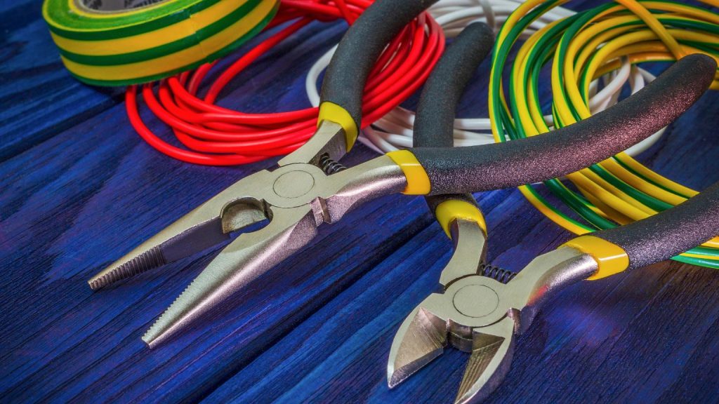 Herramientas eléctricas con alicates y cables de colores usados en instalaciones eléctricas seguras y eficientes