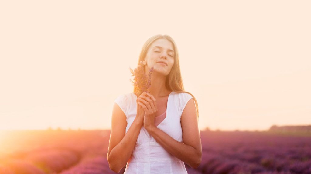 Mujer empoderada en conexión espiritual rodeada de naturaleza, representando el amor incondicional como fuerza interior.