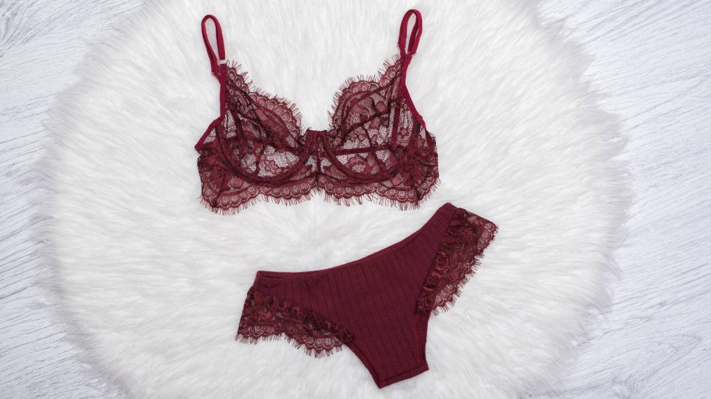 Conjunto de lencería de calidad en color burdeos sobre fondo blanco de textura suave
