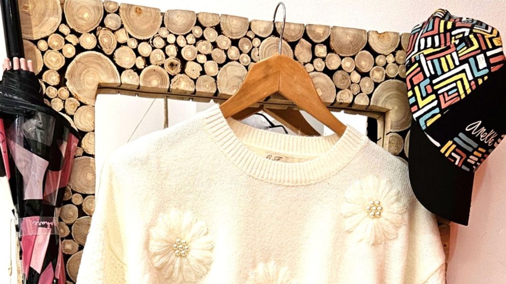 Tienda de ropa de mujer con looks y prendas de invierno en tonos cálidos.