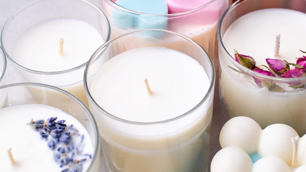 Velas artesanales en frascos de vidrio decoradas con flores secas y aromas naturales para crear ambientes de calma y bienestar