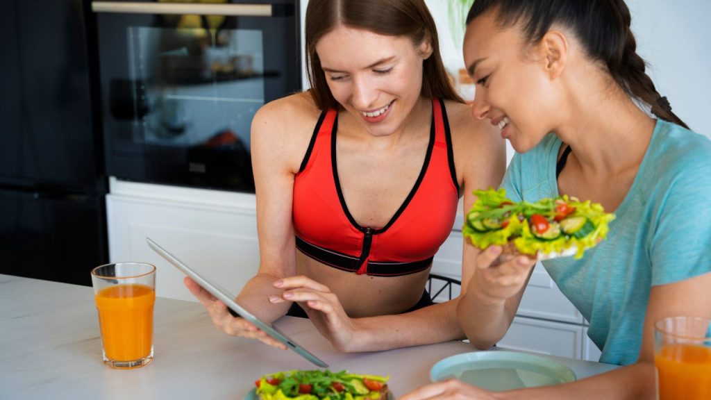 Nutricionista personalizada asesorando a un deportista principiante en consulta, plan de alimentación sobre la mesa, entorno profesional y cercano.