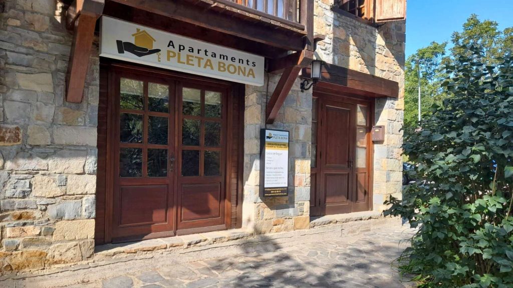 Entrada principal dels apartaments Vall de Boí envoltada de natura al Pirineu.