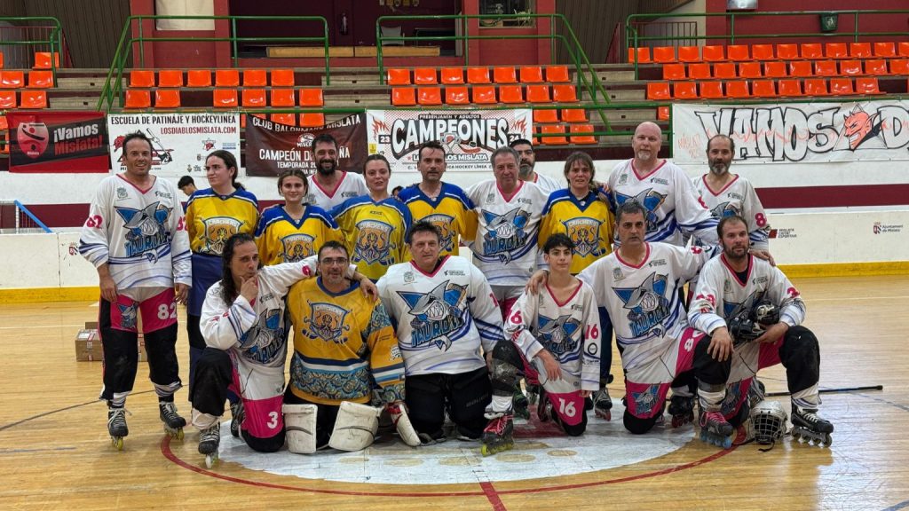Equipo en clases de hockey y patinaje infantil practicando sobre pista cubierta