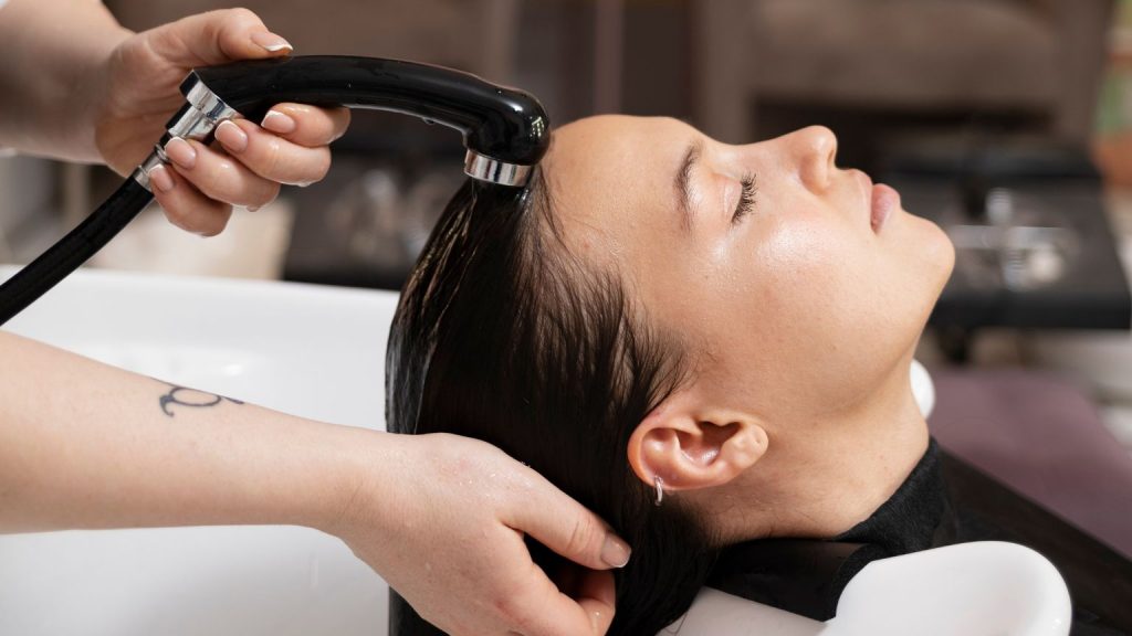 Mujer recibiendo tratamiento capilar en peluquería en Madrid para un evento especial.