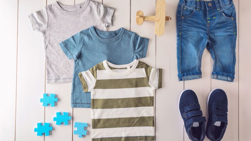 Ropa infantil hecha en España doblada sobre fondo neutro con tejidos suaves