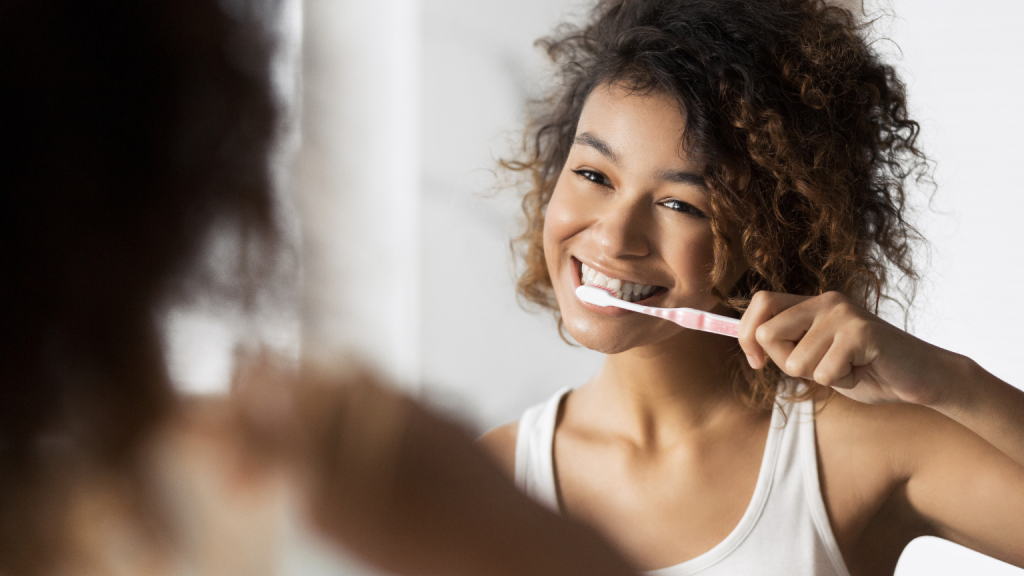 Woman practicing Toronto dental hygiene at home