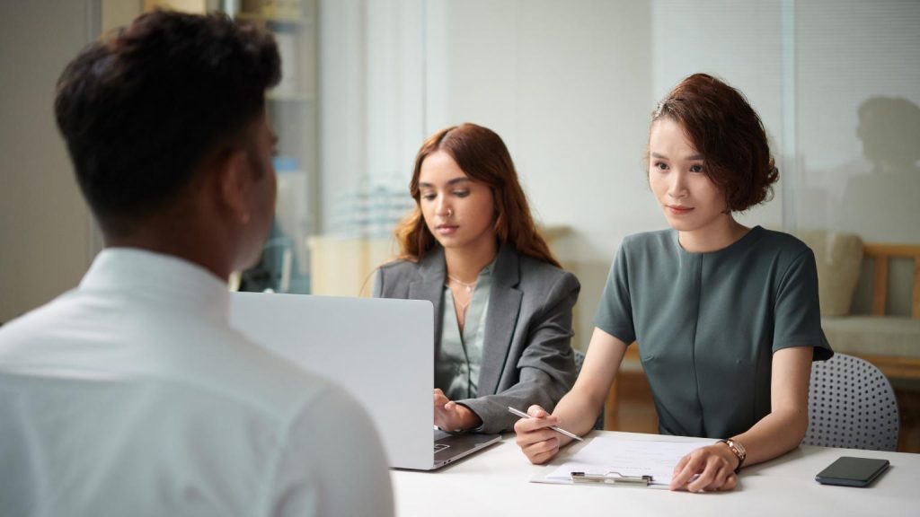Leadership recruiting interview with two female recruiters assessing a candidate during an executive hiring process in a modern office.