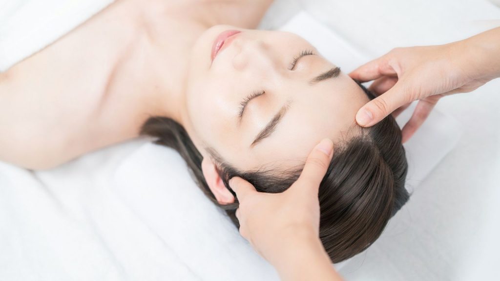 Persona recibiendo un masaje capilar japonés en Valencia en un centro de bienestar relajante