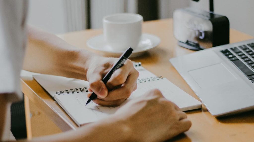 persona estudiando y tomando apuntes mientras aprende chino online en España frente a un portátil