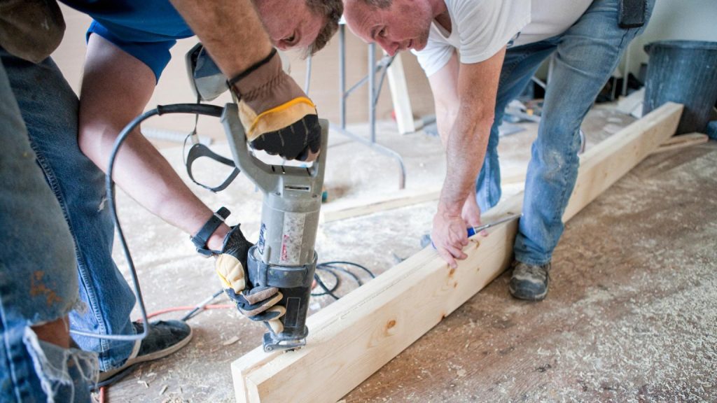 Empresa de reformas realizando trabajos de carpintería y corte de madera durante una instalación