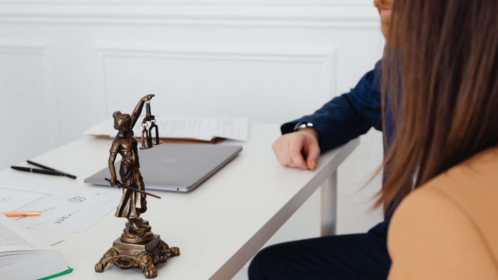 abogada profesional atendiendo cliente en despacho elegante con luz natural