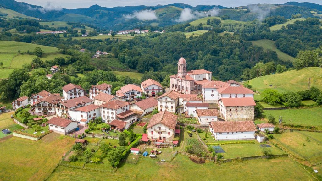 Vista aérea de un alojamiento rural en el Valle de Baztan rodeado de montañas verdes y arquitectura tradicional del norte de Navarra