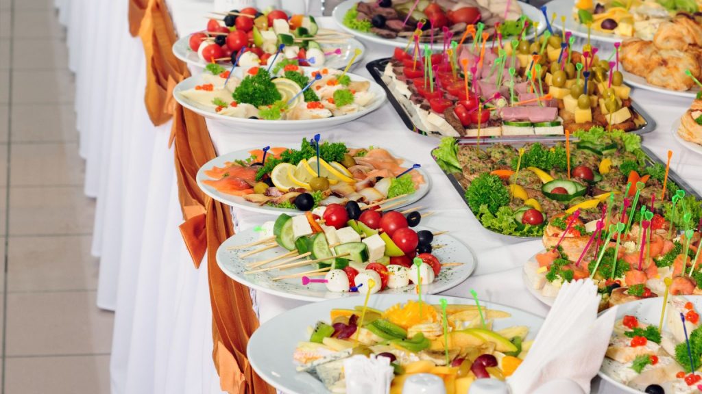 Mesa de catering con opciones vegetarianas para eventos en España, con platos variados de verduras, frutas, quesos y aperitivos presentados de forma cuidada y profesional