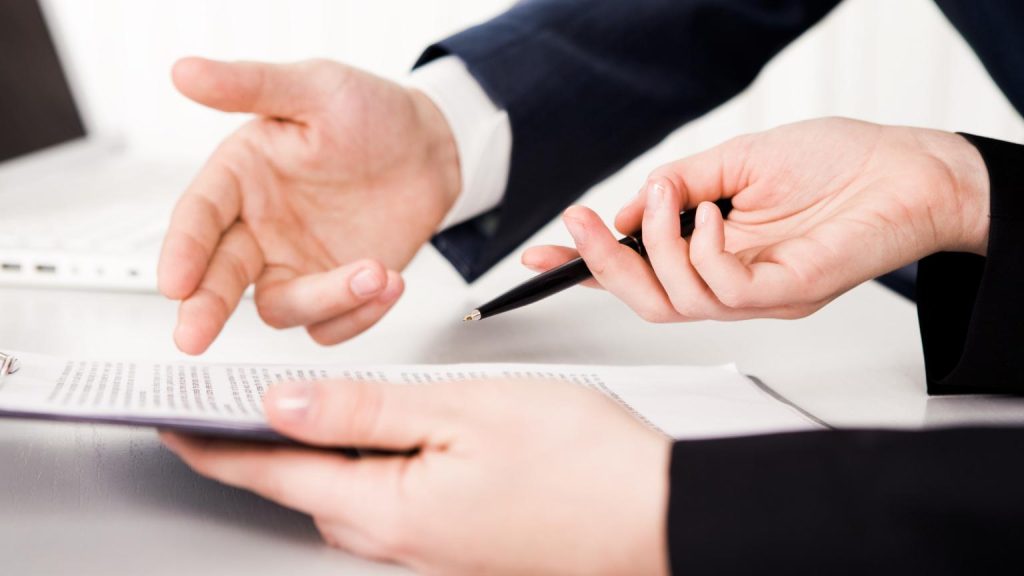 Consultoría empresarial en reunión profesional analizando documentos y tomando decisiones estratégicas