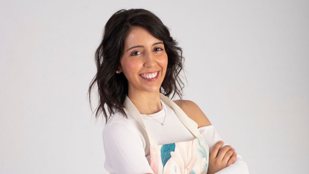 Dietista nutricionista sonriendo en consulta profesional, imagen que representa la atención cercana y el acompañamiento presencial en nutrición.