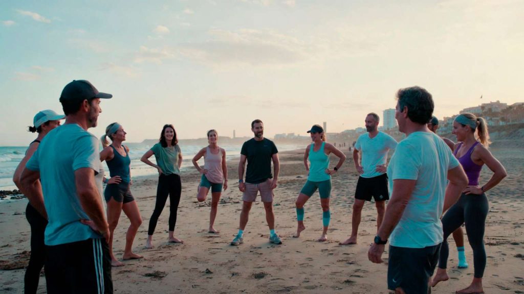 Grupo reducido entrenando al aire libre en la playa de Málaga con acompañamiento profesional, en un ambiente de salud, bienestar y comunidad.