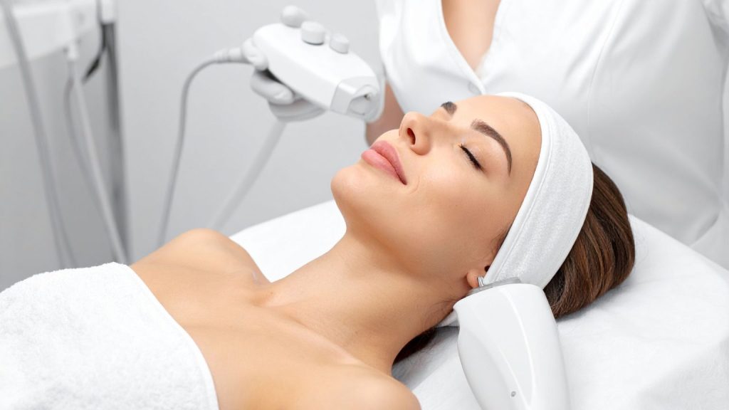 Mujer recibiendo tratamiento de estética facial en clínica profesional con enfoque consciente y cuidado de la piel