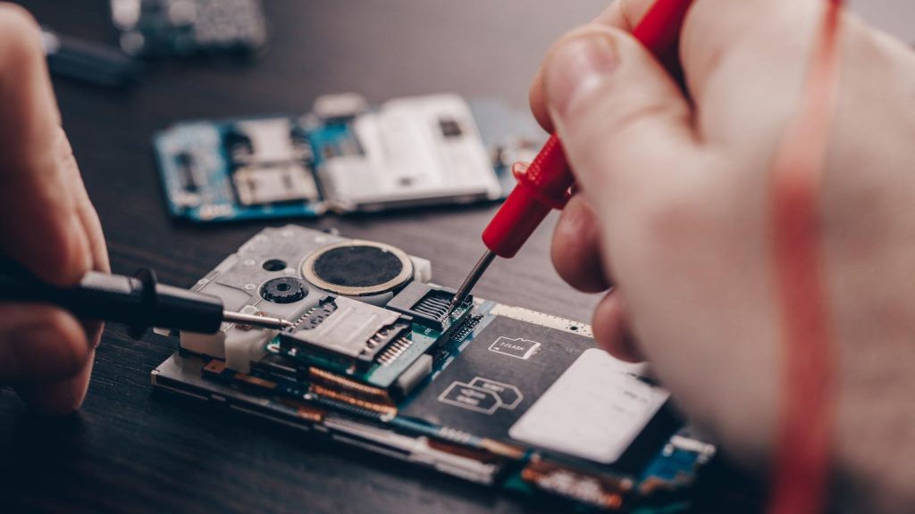 Técnico realizando reparación de dispositivos electrónicos en una tienda de electrónica profesional